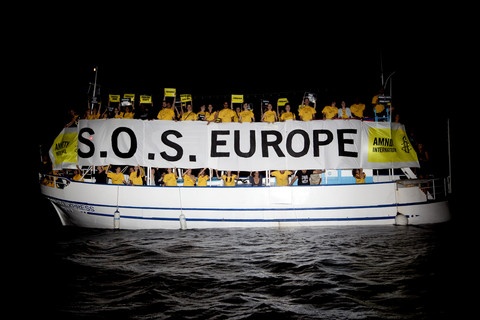 Des militants d'Amnesty envoient un SOS à l'Europe depuis l'île grecque de Lesvos, en juillet 2013. Selon des témoignages, les garde-côtes et la police des frontières grecs repoussent régulièrement les réfugiés et les migrants qui tentent d'entrer en Europe par la mer Égée et le fleuve Evros. Photo : © Amnesty International (Photo : Giorgos Moutafis)