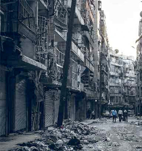 Des gens marchent au milieu des débris de bâtiments touchés par d'intenses bombardements, à Alep (octobre 2012). © AP Photo/Narciso Contréras