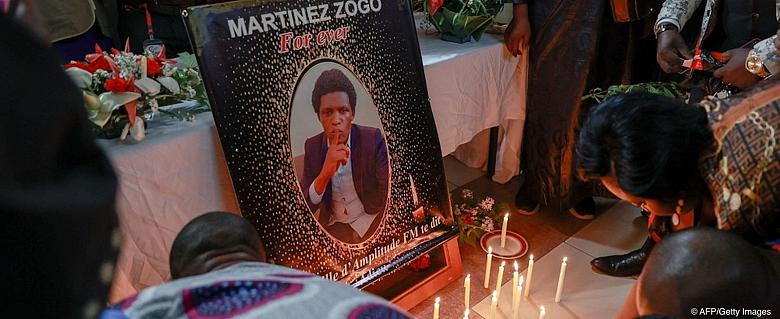 Des personnes en deuil déposent des bougies dans une salle de Radio Amplitude FM où un portrait du journaliste Martinez Zogo a été placé pour lui rendre hommage, dans le quartier Elig Essono à Yaoundé le 23 janvier 2023. ce qu'un groupe de défense des droits des médias a appelé un enlèvement a été retrouvé mort, ont déclaré son employeur et la police le 22 janvier 2023.
