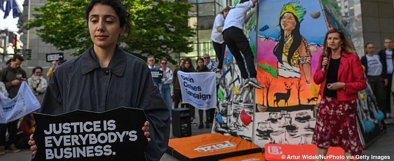 Manifestante tenant une pancarte "la justice est l'affaire de toutes et tous"