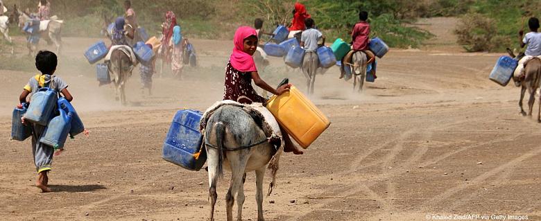jeune fille avec des bidons dos chevauchant un âne