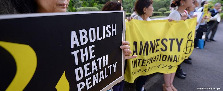 Manifestants pour l'abolition de la peine de mort défilent dans la rue avec des pancartes d'Amnesty International