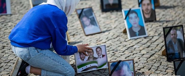 jeune fille rendant hommage à des photos de familles syriennes