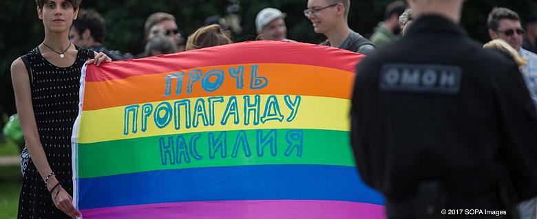 militants tenant un drapeau multicolore lgbtqia+