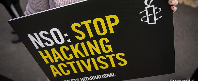 Pancarte qui dit "NSO : arrêtez de pirater les activistes"