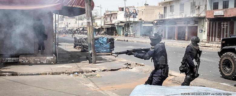 Un policier tire des balles en caoutchouc lors d'affrontements avec des manifestants à Dakar le 5 mars 2021